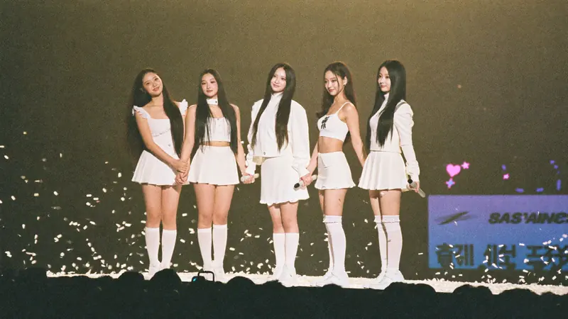 A group in white outfits on stage