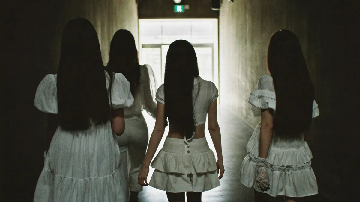 Trainees in white walking down a corridor towards a bright door